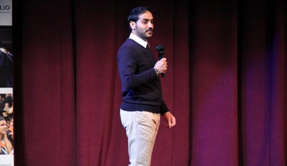 A man speaks on a stage.