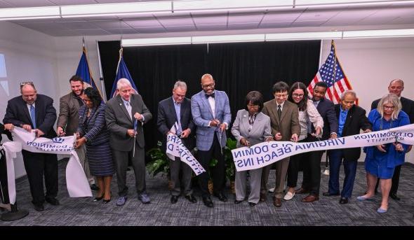 Group of people cut ribbon at an event