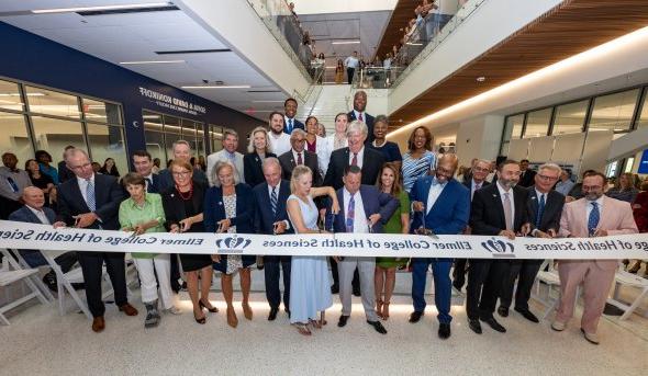 group of people cutting a grand opening ribbon