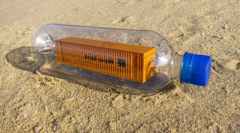 Photo of a shipping container inside a plastic water bottle.