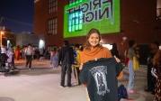 A woman holds up a T-shirt.