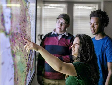 students in front of electronic map