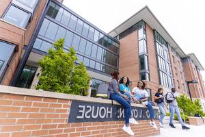 Students sitting and talking in front of Hugo Owens residence hall