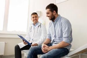 smiling doctor and young man meeting at hospital